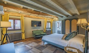 Ein Schlafzimmer mit einem Bett, einem Schreibtisch, einem Stuhl, einem Heizkörper und einem Fenster mit Vorhängen.