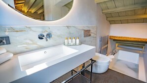 Un baño moderno con un lavamanos grande blanco, un espejo y una bañera.