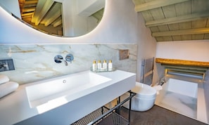 Ein modernes Badezimmer mit einem großen weißen Waschbecken, einem Spiegel und einer Badewanne.