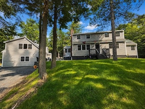 A two-story house with a front porch and a driveway. - Family Friendly getaway right across from community beach, pet-friendly with trail access (Beaver Cove)