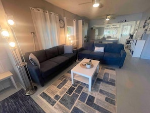 A living room with two sofas, a coffee table, and a rug. - Private Beach • Lakefront • Kayaks• Sunsets (Havana)