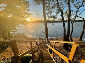 A wooden staircase leading to a dock over a calm lake, surrounded by trees. - Private Beach • Lakefront • Kayaks• Sunsets (Havana)