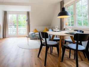 A dining area with a round table, chairs, and a large pendant light. - 10 in the Nis Randers House (St. Peter-Ording)
