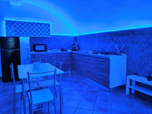 A modern kitchen with a built-in microwave, gas stove, and white cabinetry. - Enzo nel cuore di Napoli – Authentic Stay in Central Naples with Balcony (Napoli)