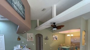 Cozinha espaçosa com área de refeições, ventilador de teto e ilha.