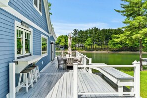 Eine Terrasse mit Sitzgelegenheit und Blick auf einen See.