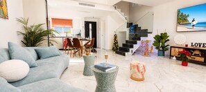 A modern living room with a sofa, coffee table, and decorative items. - Alma Nomada Luxury Village & Private Pool & BBQ & ChillOut (Corralejo)