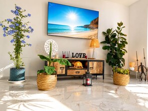 A modern living room with a beach view, a wooden cabinet, and decorative plants. - Alma Nomada Luxury Village & Private Pool & BBQ & ChillOut (Corralejo)