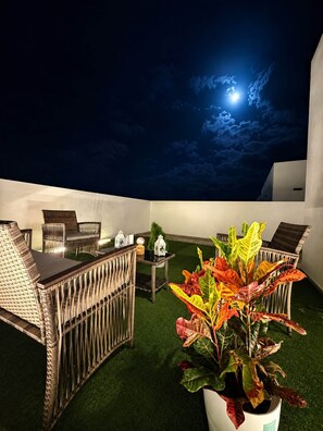 An outdoor seating area with wicker furniture and a potted plant. - Alma Nomada Luxury Village & Private Pool & BBQ & ChillOut (Corralejo)