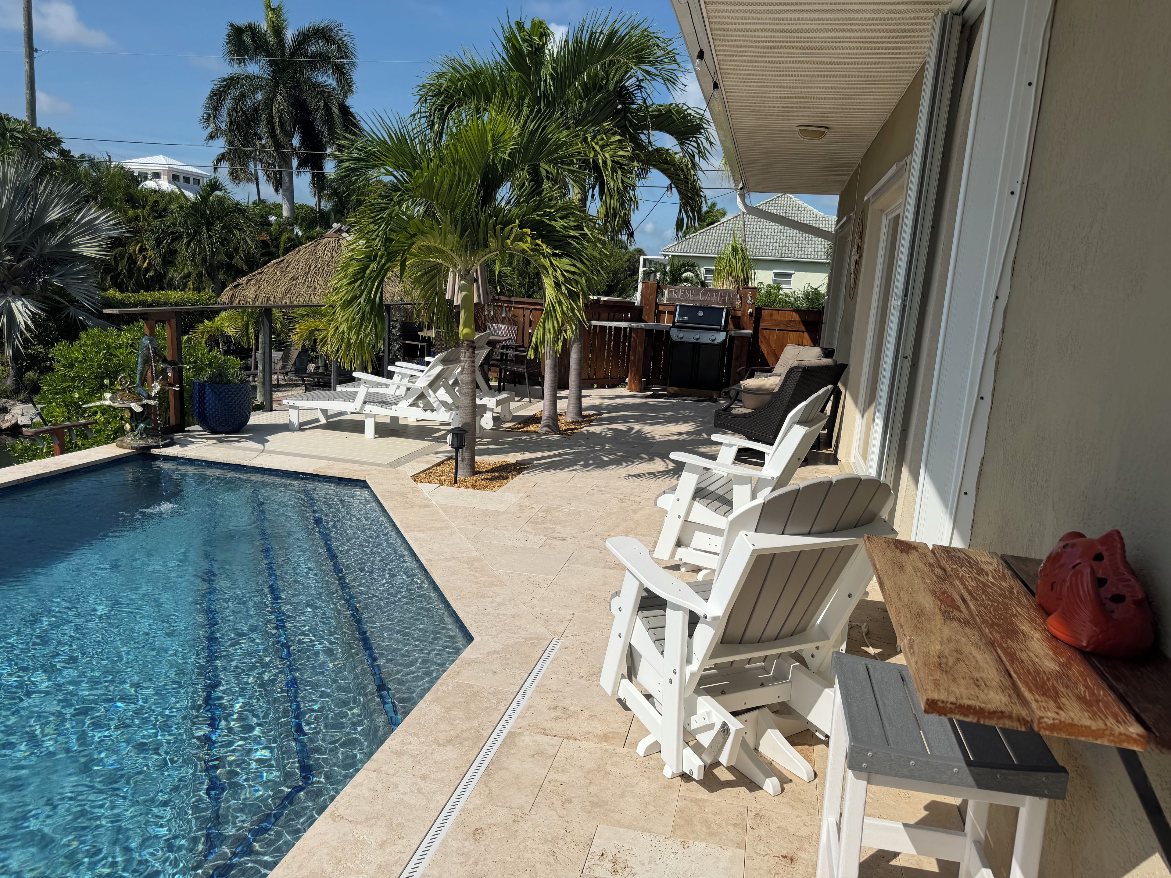 A swimming pool with lounge chairs and a barbecue area.