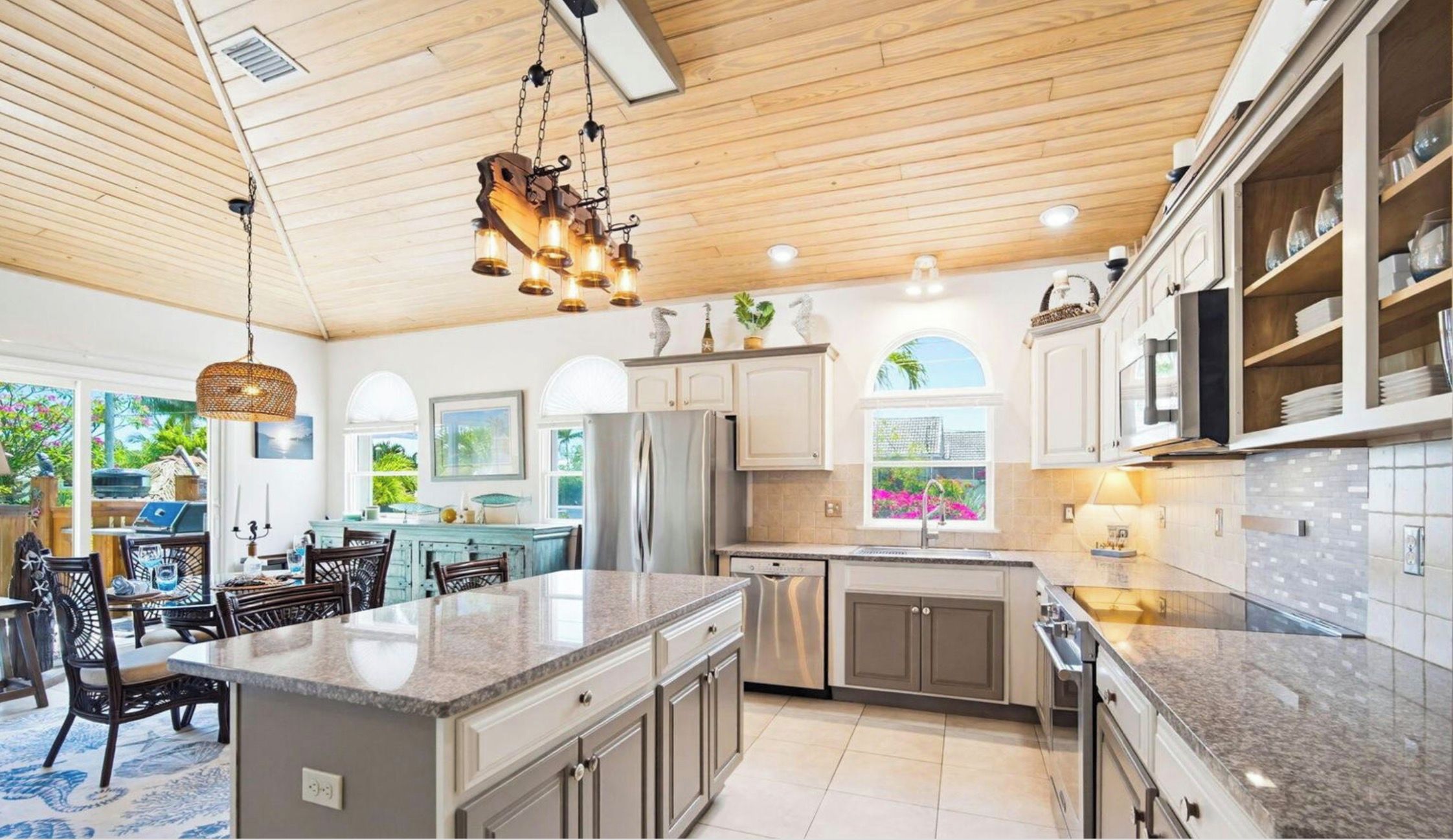 Een moderne keuken met granieten aanrechtbladen, roestvrijstalen apparatuur en een groot eiland.