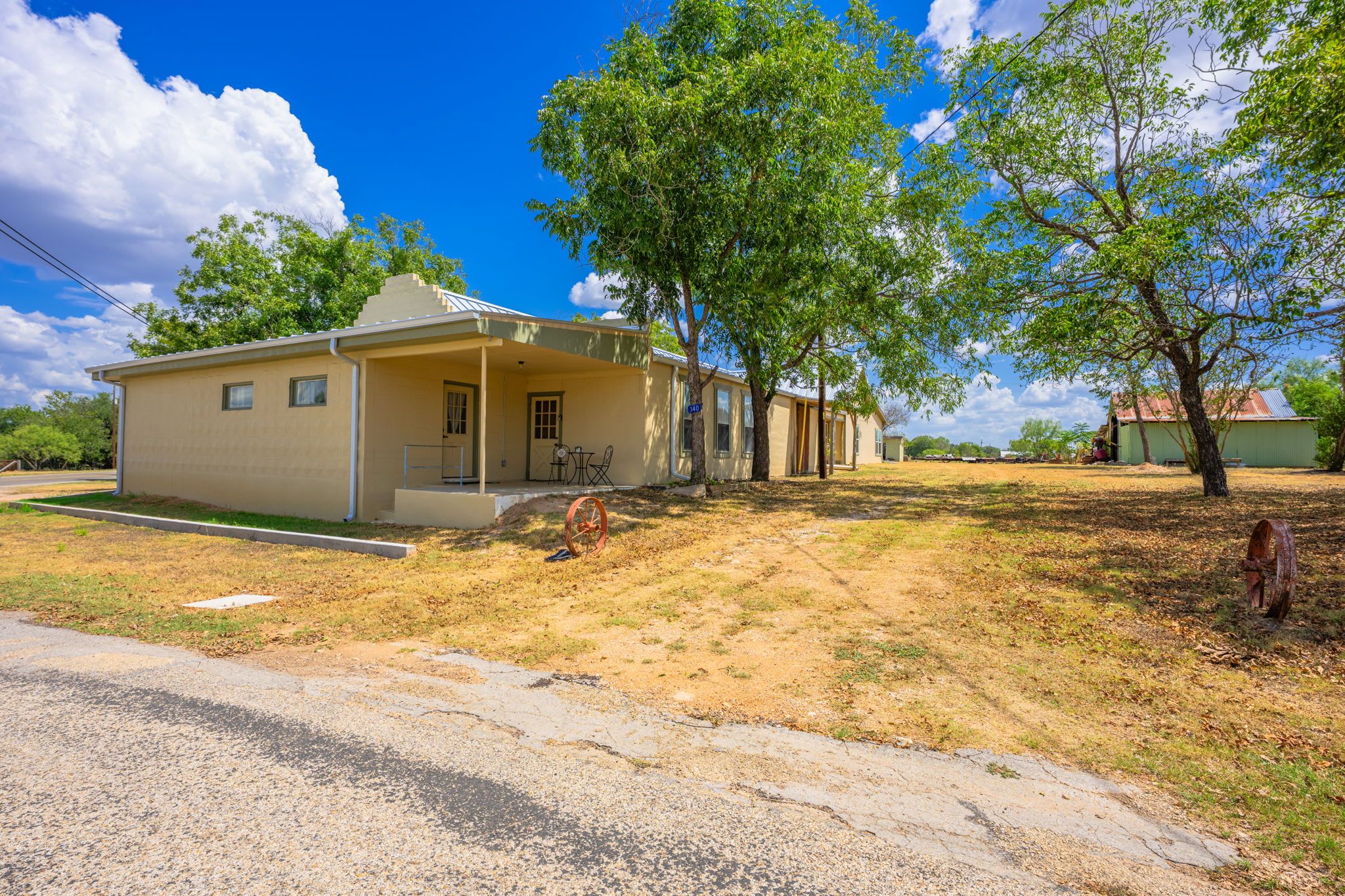 A single-story house with a porch, a small front yard, and a clear sky.