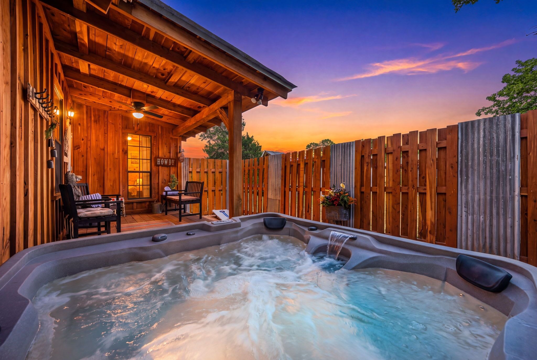 Una cabaña de madera con jacuzzi y zona de estar al aire libre.
