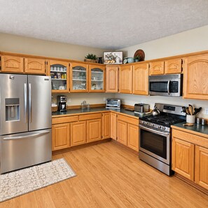 A modern kitchen with wooden cabinets, stainless steel appliances, and a built-in oven.