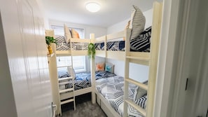 A bunk bed room with a window, a plant, and a shelf with books. - Porthminster Pad | St Ives, Parking, 2 min walk to Porthminster Beach (Saint Ives)