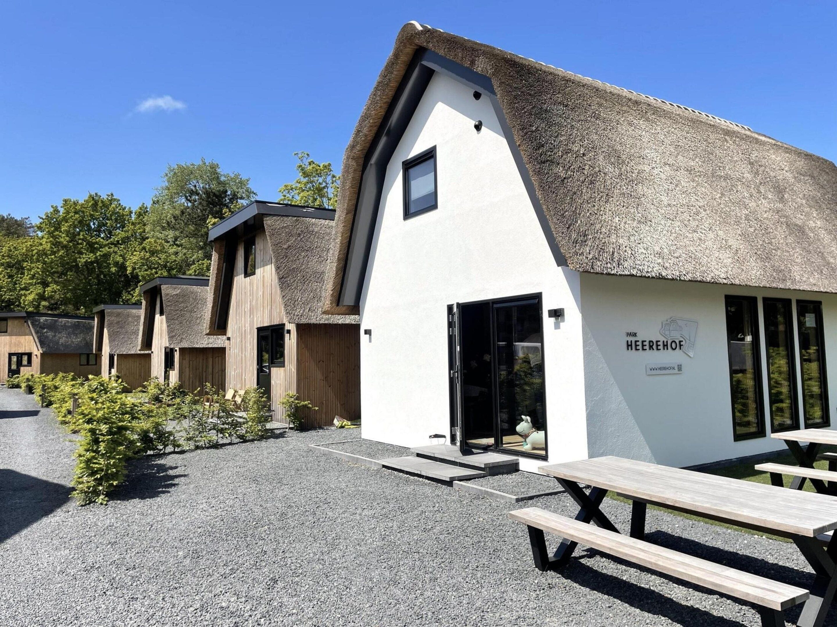 Un bâtiment doté d’un toit de chaume et d’une enseigne indiquant « HEEREHOF PARK ».