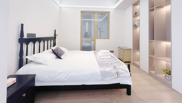 A bedroom with a bed, bedside tables, a wardrobe, and a mirror.