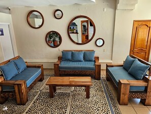 A living room with a sofa set, a coffee table, and decorative mirrors on the wall. - Hotel & Suites Mar y Sol (Rincón de Guayabitos)