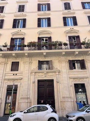 A multi-story building with a classic architectural style, featuring a central entrance with a large door and windows with shutters. - Stylish 1BR 2Bath Apartment near Castel Sant'Angelo — Prati, Rome (Rome)