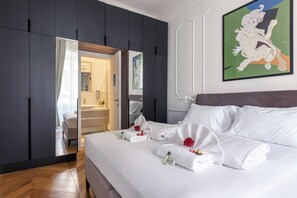 A hotel room with a large bed, a mirror, and a painting on the wall. - Stylish 1BR 2Bath Apartment near Castel Sant'Angelo — Prati, Rome (Rome)