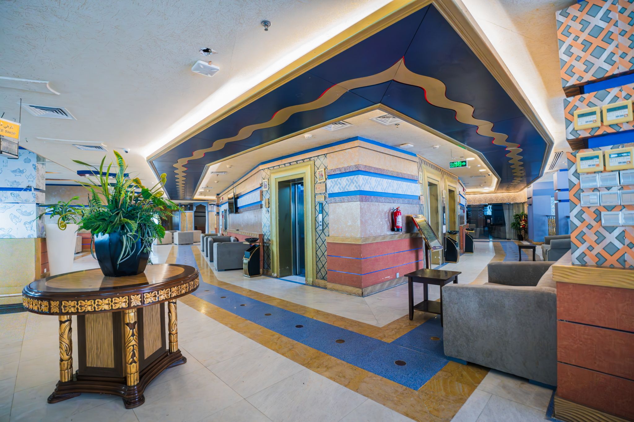 Um hall de entrada com balcão de recepção, área de estar e teto decorativo.