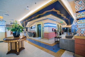 A lobby with a reception desk, seating area, and a decorative ceiling. - فندق تلال اليقين (Makkah)