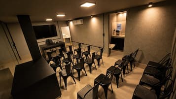 A conference room with tables and chairs, a whiteboard, and a water dispenser.