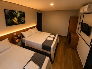 A hotel room with two beds, a TV, a painting, and an air conditioning unit. - Olla Hotel  (Montes Claros)