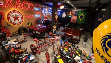A garage with various vehicles, including cars and motorcycles, and a Texaco sign.