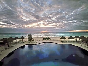 Ein Pool mit Blick auf das Meer und Strandstühle.