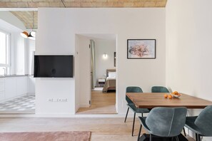 A modern living space with a kitchen, dining area, and a bedroom visible through an open door. - Charming 1BR Apartment with Balcony near Vatican — Prati, Rome (Rome)