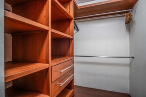A wooden closet with open shelves and a hanging rod.