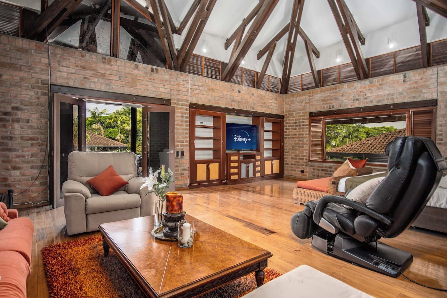 A spacious living area with a fireplace, comfortable seating, and a large television screen.