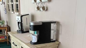 Une petite cuisine équipée d’une machine à café, d’un grille-pain et d’un porte-tasses.