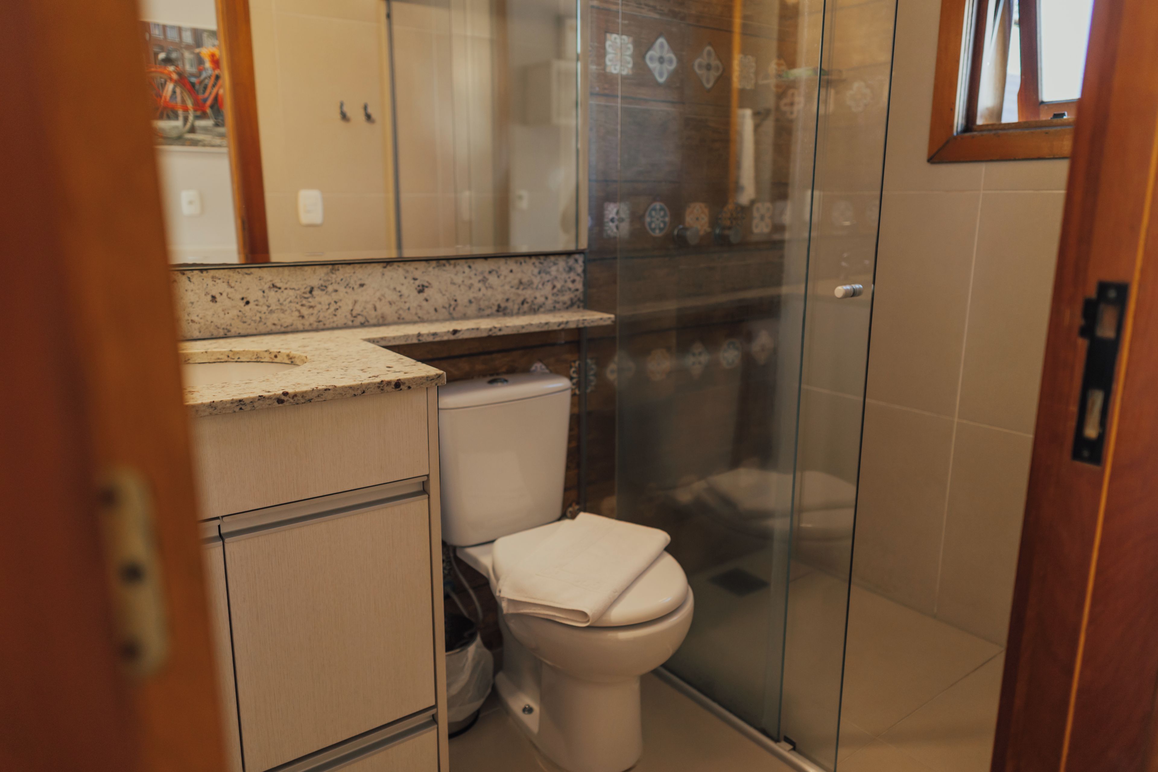 A bathroom with a toilet, a shower enclosure, and a sink.