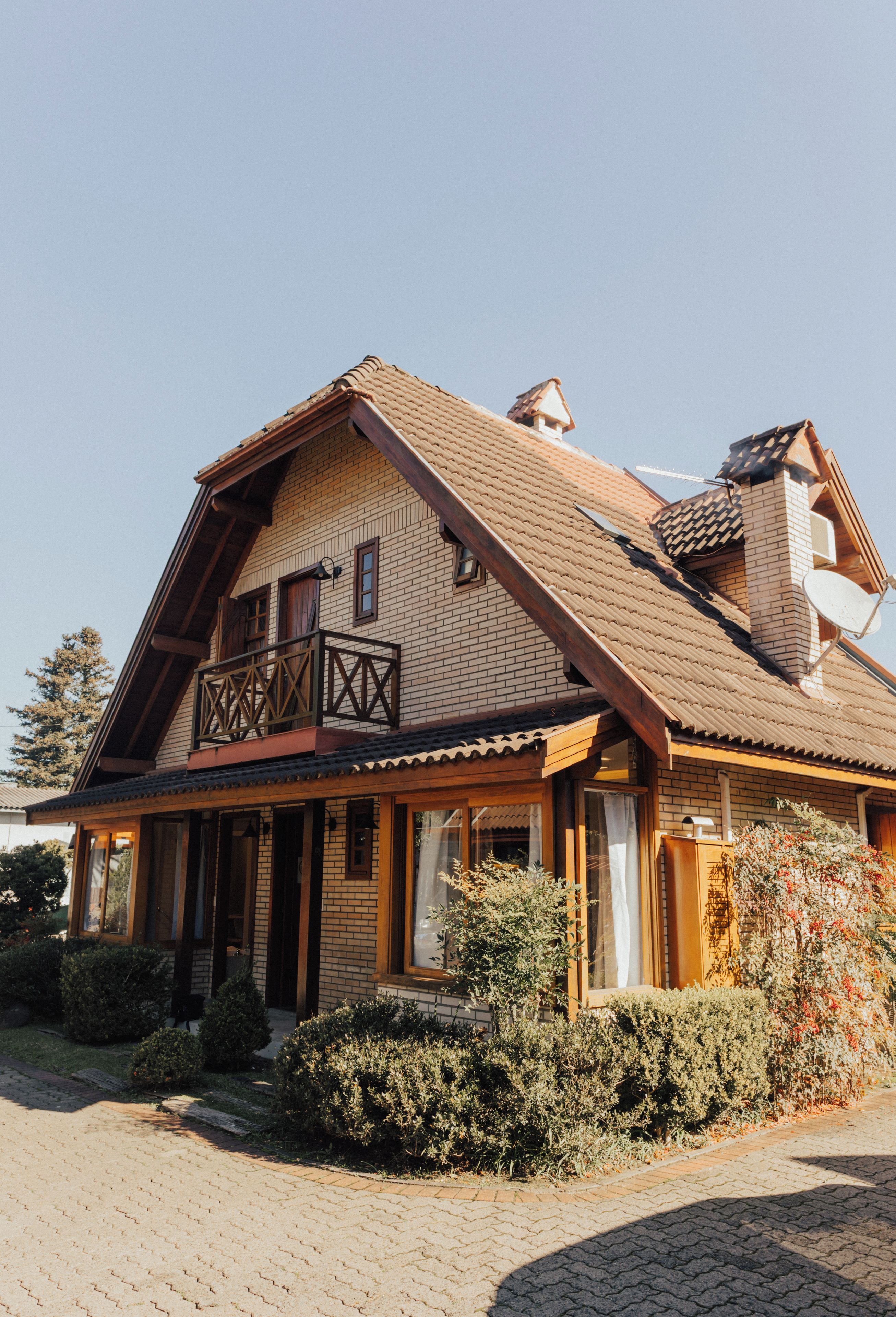Une maison à deux étages avec un balcon, une cheminée et une antenne parabolique.