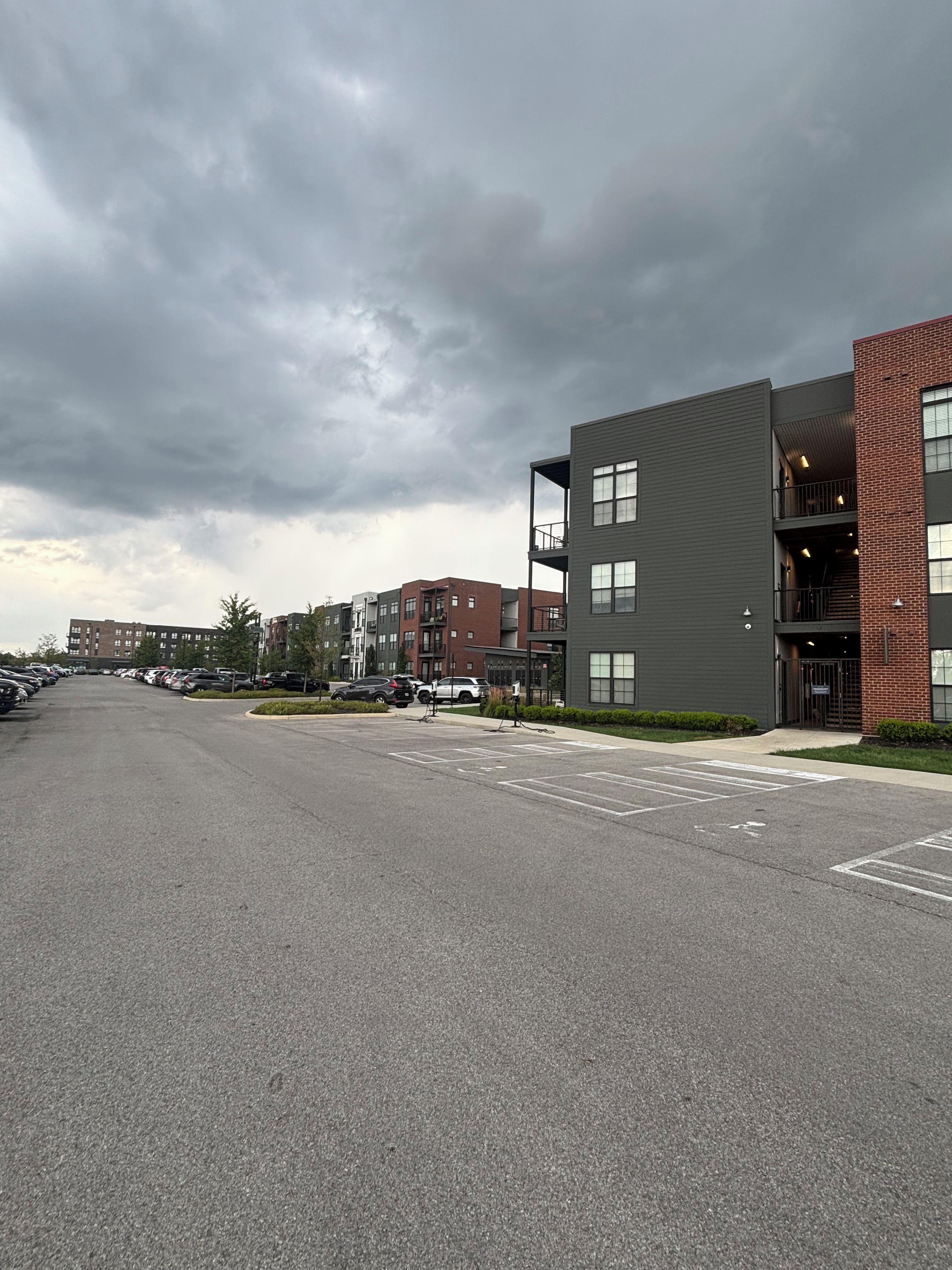 Un parking à étages doté d’une architecture moderne, caractérisé par une combinaison de matériaux, notamment de la brique et du métal, pour les façades.