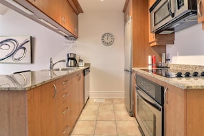 A kitchen with wooden cabinets, a stainless steel sink, a microwave, and an oven. - 3 bedrooms with heated pool (summer) Walk to slopes (Saint-Sauveur)