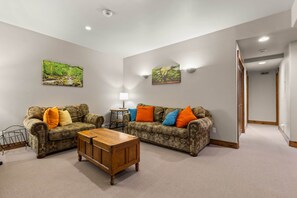 A living room with two patterned sofas, a wooden coffee table, and two wall-mounted lamps. - Eagle’s Rest – Your Mountain Getaway (Steamboat Springs)