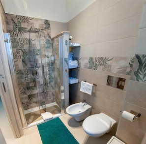 A bathroom with a glass-enclosed shower, a toilet, a bidet, and a sink. - Addu' Me Apartment with Balcony, Wi-Fi, and Air Conditioning (Napoli)