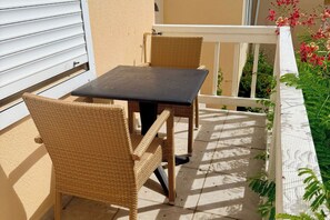 A balcony with a table and two wicker chairs. - 1-Bedroom Apartment in Pelican Key with Shared Pool & Balcony (Koolbaai)