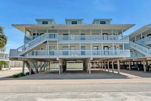 A multi-story building with balconies and a covered parking area. - The Surf Shack | Gulf Shores Getaway (Gulf Shores)