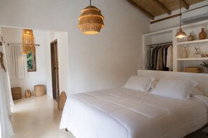 Ein Schlafzimmer mit einem großen Bett, einem Kleiderschrank und einem Regal mit Dekoration.