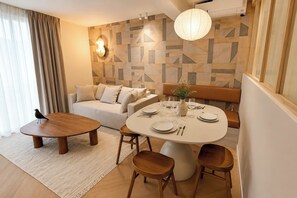A modern living room with a round dining table, sofa, and a bird on the floor. - TheBlueStay 356 - Stunning Apartment A/C Paris 11 (Paris)