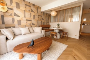 A modern living room with a sofa, coffee table, and a dining area with stools. - TheBlueStay 356 - Stunning Apartment A/C Paris 11 (Paris)
