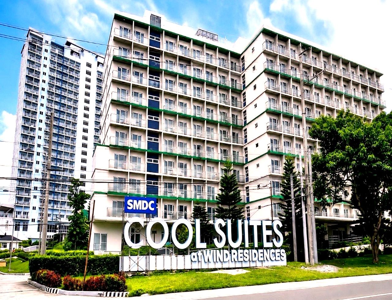 A multi-story building with balconies, labeled 'SMDC COOL SUITES at WIND RESIDENCES.'