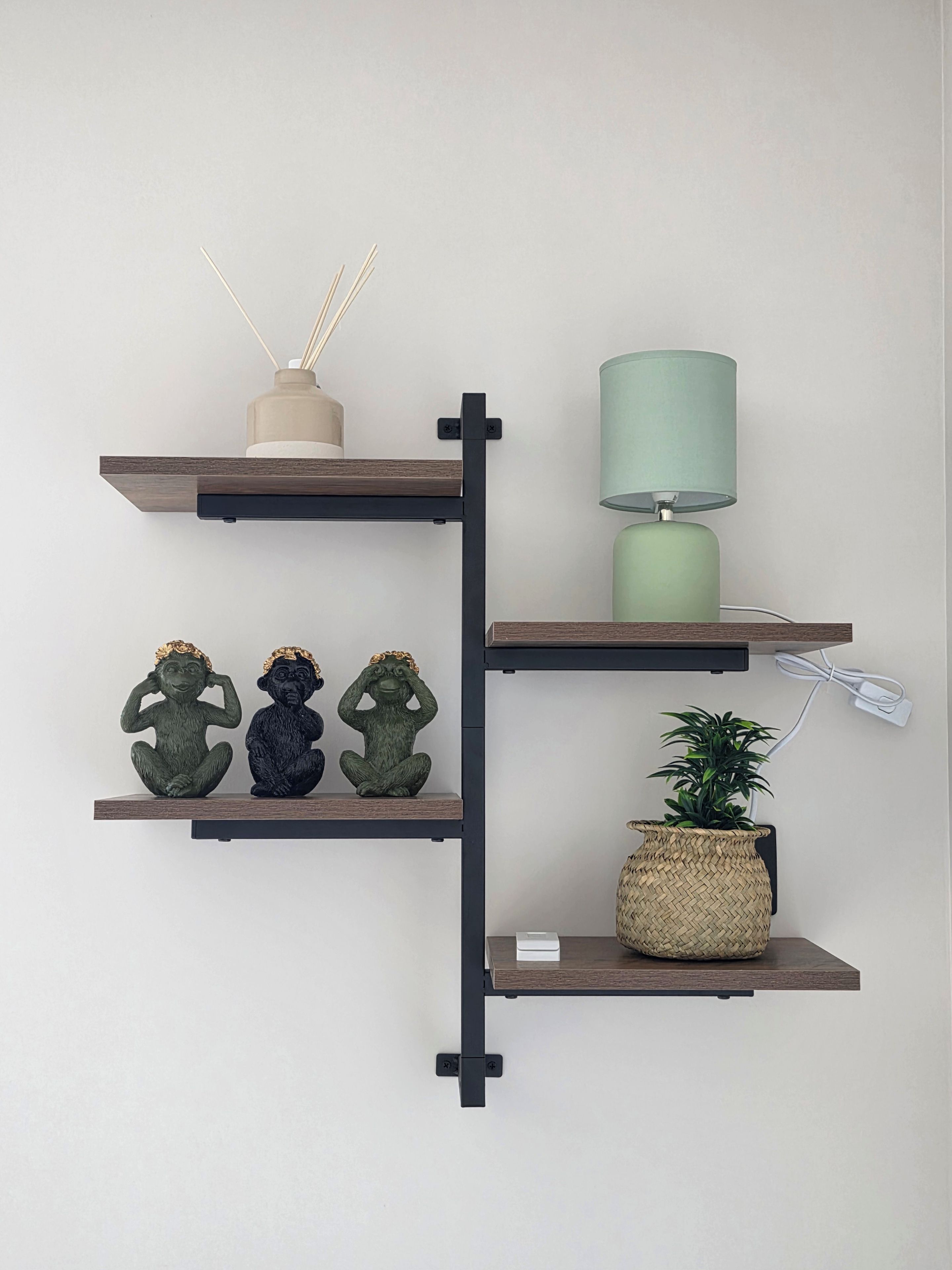 En vægmonteret hylde med dekorative genstande og en lampe.