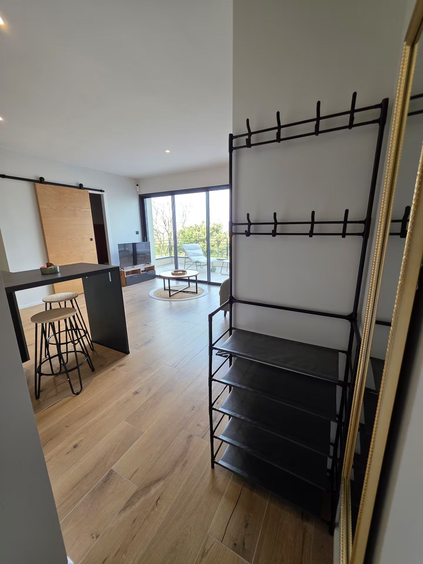 Een modern interieur met een keukenhoek, een eethoek en een groot raam met uitzicht.