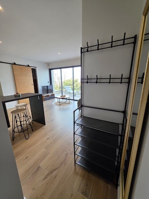 A modern interior with a kitchen area, a dining space, and a large window offering a view.