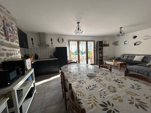 Una cocina moderna con comedor, sofá y vistas a través de un ventanal.